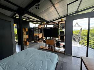 a bedroom with a bed and a flat screen tv at Entre Bambús in Pereira