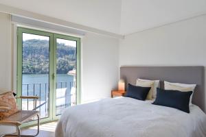 a bedroom with a large bed and a large window at Feel Discovery Casa de Cima Douro Valley in Riba Douro
