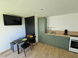 a kitchen with a table with chairs and a counter top at La Maisonette in Plounevez-Moëdec