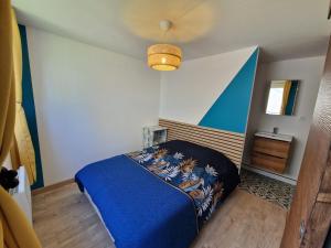 a bedroom with a blue bed with a blue blanket at La Maisonette in Plounevez-Moëdec