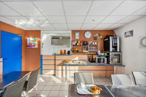 a kitchen and dining room with a table and chairs at Hôtel AKENA Chateaurenard - Parc des Expositions Avignon in Châteaurenard