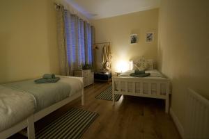 sypialnia z dwoma łóżkami i stołem z lampą w obiekcie Dundrine Cottage w mieście Maghera