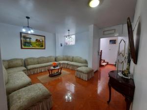 a living room with couches and a table at Amplio departamento in Loja