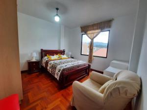 a bedroom with a bed and a couch and a window at Amplio departamento in Loja