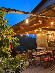 a patio with a table and chairs under a roof at Casa Camerana 16 personnes in Camerana 