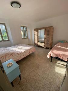 a bedroom with a bed and a table and a mirror at Casa Camerana 16 personnes in Camerana 
