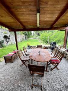 a wooden table and chairs under a wooden roof at Casa Camerana 16 personnes in Camerana 