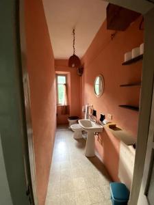an orange bathroom with two sinks and a mirror at Casa Camerana 16 personnes in Camerana  +60 photos