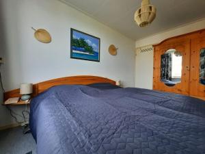 Schlafzimmer mit einem großen Bett mit blauer Decke in der Unterkunft Lamsoor 20 in Nieuwvliet