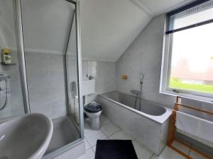 ein Badezimmer mit Waschbecken, Badewanne und Toilette in der Unterkunft Lamsoor 20 in Nieuwvliet + 23 Fotos