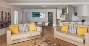 a living room with two white couches and yellow pillows at Flamingo Beach Mate in Adeje