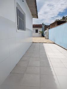 een loopbrug naar een wit gebouw bij Casa com piscina in Peruíbe