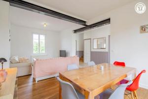 a living room with a wooden table and chairs at L'Albatros, Villa de charme familiale classée 3 étoiles, All inclusive in Paray-le-Monial