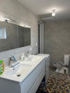 a bathroom with two sinks and a toilet at L'Albatros, Villa de charme familiale classée 3 étoiles, All inclusive in Paray-le-Monial +27 photos