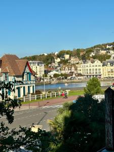 a view of a town with a river and buildings at Mermoz Vue Mer, Parking in Deauville