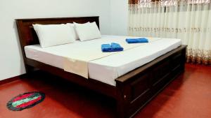 a bed with two blue towels on top of it at Sohansa Guesthouse in Weligama