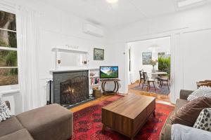 a living room with a couch and a fireplace at Historic Corinda Cottage in Bundanoon