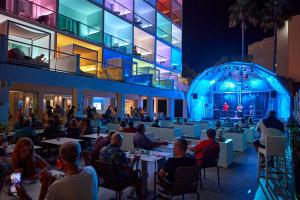 a group of people sitting at tables outside of a building at Hotel Astoria Playa Adults Only 4* Sup in Port d'Alcudia
