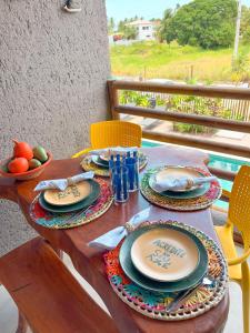 une table en bois avec des assiettes de nourriture dessus dans l'établissement Lindo loft a poucos metros da Praia no Patacho!, à Porto de Pedras