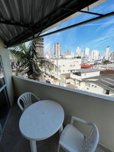 a table and chairs on a balcony with a view of a city at Pousada Morada das Nações in Balneário Camboriú
