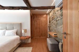 a bedroom with a bed and a stone wall at Feel Discovery Casa da Pedra in Arouca +13 photos