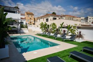 una piscina con sedie a sdraio accanto a un edificio di Villa Carmen Albir a Albir