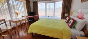 ein Schlafzimmer mit einem gelben Bett, einem Tisch und Stühlen in der Unterkunft Casa Maxi 488 in Cusco