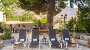 a group of chairs and a table and a tree at Huerta La Niña Arenas Órgiva by Ruralidays in Órgiva +2 photos