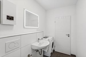 La salle de bains blanche est pourvue d'un lavabo et d'un lave-linge. dans l'établissement DDHomes LahnLiebe App 01 - Balkon,Therme,SmartTV, à Bad Ems 57 autres photos