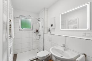 a white bathroom with a sink and a toilet at DDHomes LahnLiebe App 01 - Balkon,Therme,SmartTV in Bad Ems +33 photos