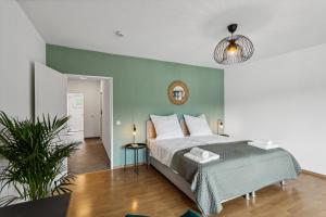 a bedroom with a bed and a green wall at DDHomes LahnLiebe App 01 - Balkon,Therme,SmartTV in Bad Ems