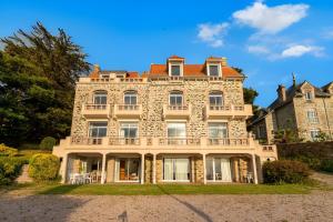 una gran casa de piedra con una torreta en Vue imprenable sur la mer pour 7 pers à Pléneuf, en Pléneuf-Val-André