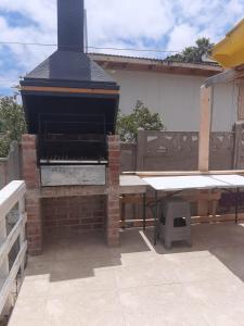 un barbecue all'aperto con tavolo e tavolo da picnic di Linda casa con piscina en el quisco. a El Quisco
