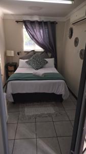 a bedroom with a bed with a window and a bed sidx sidx sidx at The cosy haven nr 2 in Harrismith