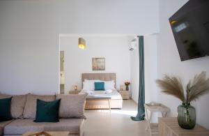 アイギナにあるKyma Aegina Suitesのソファとベッドのあるリビングルーム