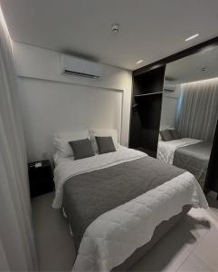 a bedroom with two beds and a mirror at Paraíso Porto Alto in Porto De Galinhas