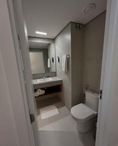 a bathroom with a white toilet and a sink at Paraíso Porto Alto in Porto De Galinhas
