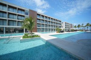 a hotel with a swimming pool in front of a building at Paraíso Porto Alto in Porto De Galinhas +15 photos