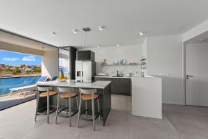 una cucina con isola, sgabelli e piano di lavoro di The Wharf 7E city apartment, overlooking Annabay, downtown Willemstad a Willemstad
