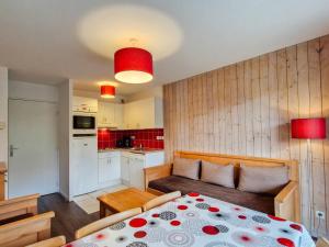 sypialnia z łóżkiem i kuchnia z czerwonymi ścianami w obiekcie Appartement lumineux avec balcon sud, centre station, parking couvert - Flaine Forêt - FR-1-425-141 w mieście Flaine