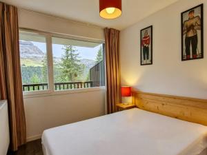 sypialnia z łóżkiem i dużym oknem w obiekcie Appartement lumineux avec balcon sud, centre station, parking couvert - Flaine Forêt - FR-1-425-141 w mieście Flaine