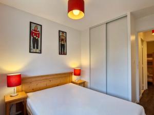 sypialnia z białym łóżkiem i 2 lampami w obiekcie Appartement lumineux avec balcon sud, centre station, parking couvert - Flaine Forêt - FR-1-425-141 w mieście Flaine