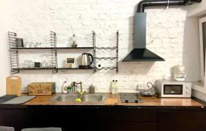 Una cocina con fregadero y una pared de ladrillo blanco. en Duo Apartment Durres Center, en Durrës 9 fotos más