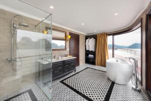 uma casa de banho com uma banheira e um chuveiro em vidro. em Aqua Of The Seas Cruise Halong em Ha Long