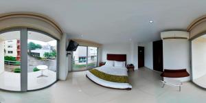 a bedroom with a bed and a large window at Hotel Ipanema Meridian in Neiva