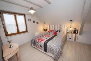 ein Schlafzimmer mit einem Bett und einem Tisch und Fenstern in der Unterkunft Le clocher aux cigognes au village de Bergheim in Bergheim + 16 Fotos