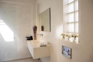 アイギナにあるKyma Aegina Suitesの洗面台と鏡のある白いバスルーム +81枚の写真