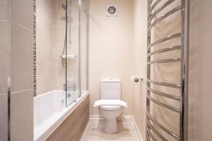 een badkamer met toilet en ligbad bij Marlborough House - Guest House in Oxford