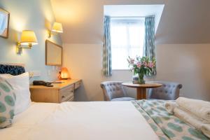 een hotelkamer met een bed, een tafel en een raam bij Marlborough House - Guest House in Oxford