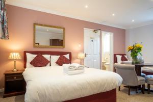 een slaapkamer met een bed met een spiegel en een tafel bij Marlborough House - Guest House in Oxford